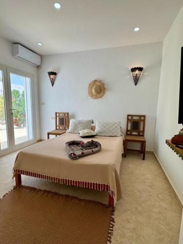 a bedroom with a large bed and a window at Villa Paco Djerba 2 suites et piscine privée in Taguermess