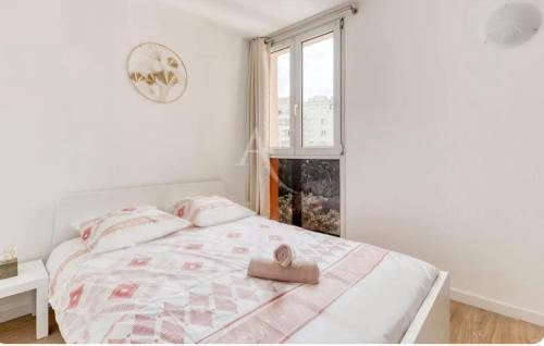 a white bedroom with a bed with a towel on it at Urban Paradise near Orly Airport and Paris in Thiais