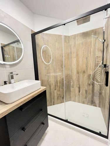 une salle de bain avec une douche avec un lavabo et une baignoire dans l'établissement Résidence Port Royal - Appartement 6 couchages au centre du Grau du roi MAE-9831, au Grau-du-Roi