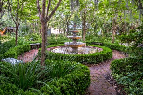 a fountain in the middle of a garden at Magnolia Plantation & Cottages in Gainesville