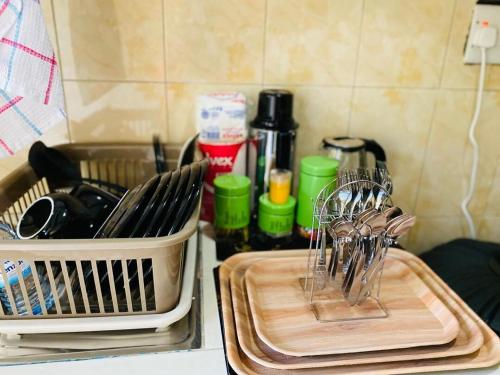 a kitchen counter with a cutting board and utensils at Blooming Homes Uganda in Kyebando