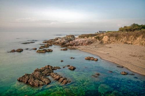 an aerial view of a beach with rocks in the water at Le Clos de la Côte Sauvage in Piriac-sur-Mer