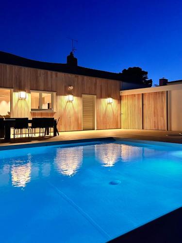 une piscine devant une maison la nuit dans l'établissement Le Clos de la Côte Sauvage, à Piriac-sur-Mer