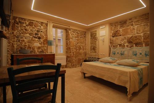 a bedroom with two beds and a table and chairs at Suite Principe Umberto Alghero Centralissima in Alghero
