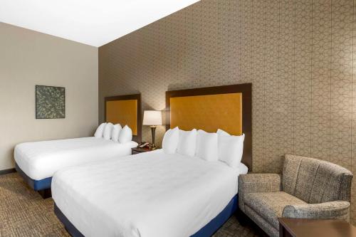 a hotel room with two beds and a chair at Best Western Plus Grant Creek Inn in Missoula