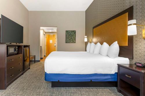 a hotel room with a large bed and a flat screen tv at Best Western Plus Grant Creek Inn in Missoula