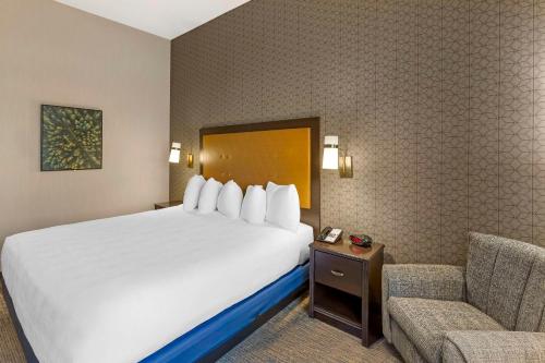a hotel room with a bed and a chair at Best Western Plus Grant Creek Inn in Missoula
