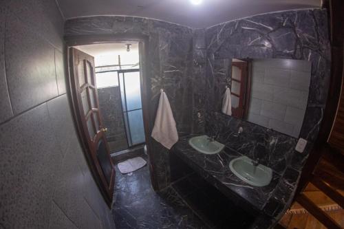 a black marble bathroom with two sinks and a mirror at Hermosa villa con piscina in Ambuquí