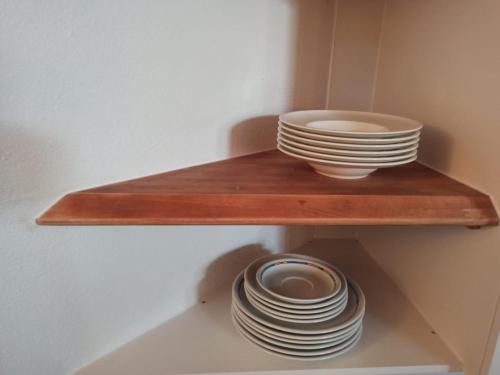 a wooden shelf with plates and bowls on it at Einzimmerwohnung mit Doppelbett in Nagold