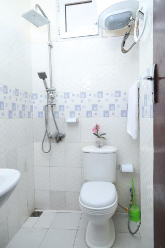 a white bathroom with a toilet and a sink at Charmant appartement Yoff-plage Bceao in Dakar