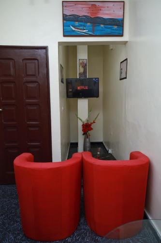 two red chairs and a table in a room at Charmant appartement Yoff-plage Bceao in Dakar