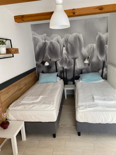 two beds in a room with a wall mural at Levendula Apartmanház in Badacsonytomaj