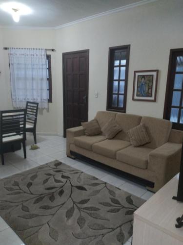 ein Wohnzimmer mit Sofa und Tisch in der Unterkunft Casa Temporada Rio das Ostras in Rio das Ostras