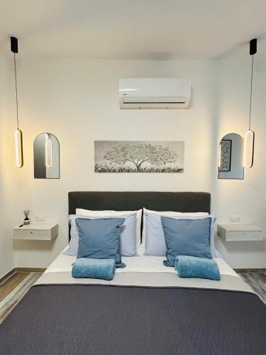 a bedroom with a bed with blue pillows at WelcHome Vitorchiano in Vitorchiano