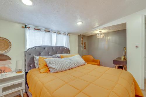 ein Schlafzimmer mit einem Bett mit einer orangefarbenen Bettdecke in der Unterkunft Walk to Memorial Stadium Family Home with Patio in Lincoln
