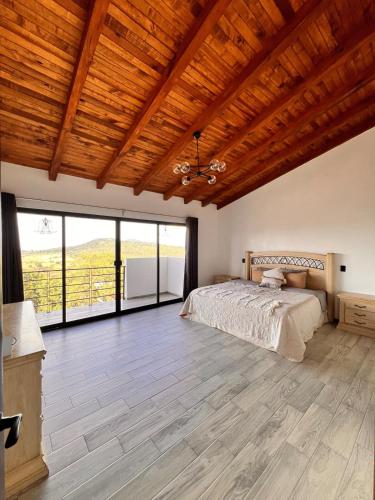 a bedroom with a bed and a wooden ceiling at Cabaña Nurela in Mazamitla