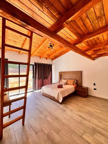 a bedroom with a bed and a wooden ceiling at Cabaña Nurela in Mazamitla