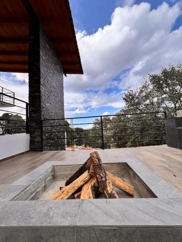 a pile of logs in a fire pit on a patio at Cabaña Nurela in Mazamitla