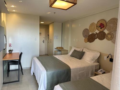 a bedroom with two beds and a table and a desk at Gran Lençóis Flat Residence Mandacaru 311 - 611 in Barreirinhas
