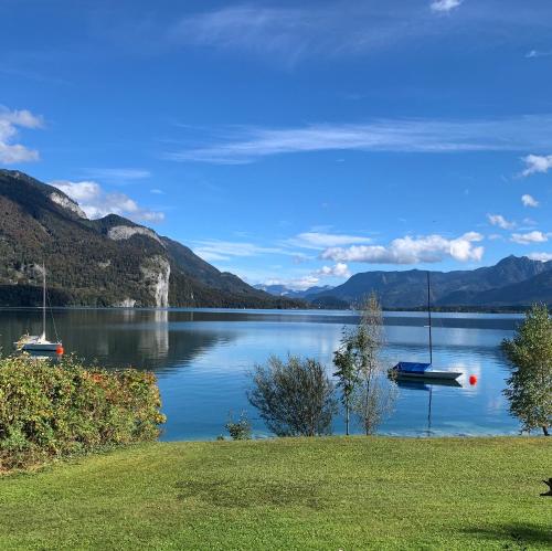 two boats on a lake with mountains in the background at Bergpanorama in Sankt Gilgen