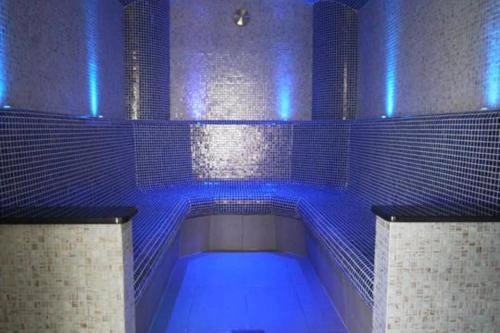 ウェルズにあるThe Byre - Luxury Barn, near Wells, Somerset, pool, gymのバスルーム(ブルーライト付きのバスタブ付)