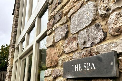 ウェルズにあるThe Byre - Luxury Barn, near Wells, Somerset, pool, gymの石造りの建物脇の看板
