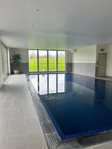 a large swimming pool in a building with a pool at The Byre - Luxury Barn, near Wells, Somerset, pool, gym in Wells