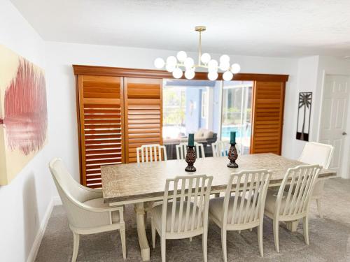 a dining room with a table and chairs at LE BLEU Charming Poolside Retreat in Bonita Springs