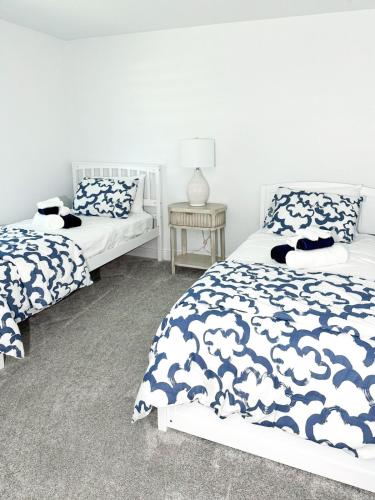 a bedroom with two beds with blue and white comforter at LE BLEU Charming Poolside Retreat in Bonita Springs
