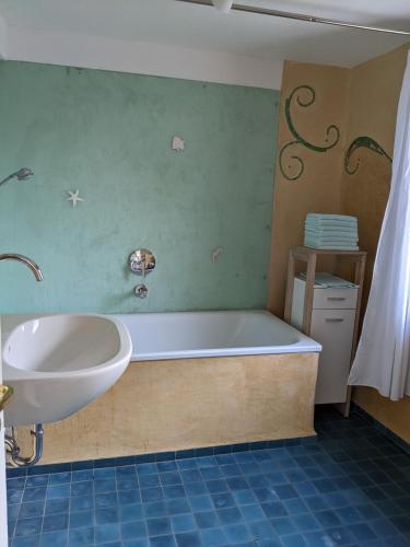 a bathroom with a bath tub and a sink at Ferienhäuschen mit Hof in Birlenbach in Birlenbach