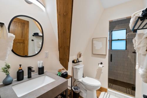 a bathroom with a sink and a toilet and a mirror at LUXE Lake Adger-Lakefront Home, Private Dock, Hot Tub, Fire Pit, Canoe, Epic Mtn & Lake Views, Universal EV Station in Mill Spring