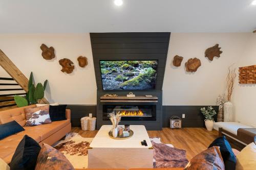 a living room with a couch and a tv at LUXE Lake Adger-Lakefront Home, Private Dock, Hot Tub, Fire Pit, Canoe, Epic Mtn & Lake Views, Universal EV Station in Mill Spring