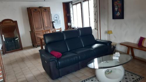 - un salon avec un canapé noir et une table en verre dans l'établissement Oiseau Bleu, à Dieppe