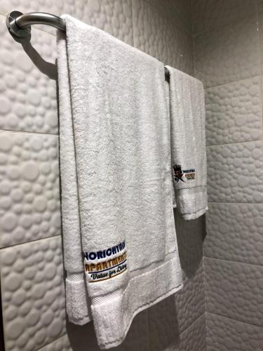 a group of towels hanging on a towel rack in a bathroom at Norichyank Apartments in Amasaman