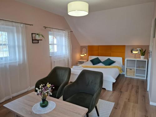 ein Schlafzimmer mit einem Bett und zwei Stühlen und einem Tisch in der Unterkunft Pokoje u Magdy in Kazimierz Dolny