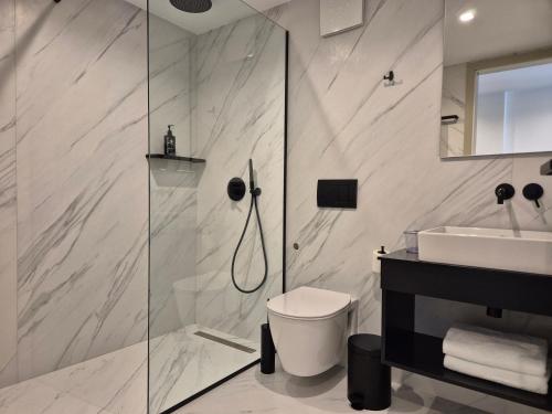 a bathroom with a shower and a toilet and a sink at Meraviglia Boutique Hotel in Sarandë
