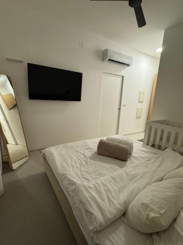 a bedroom with a bed with a flat screen tv on the wall at סוויטה פרטית ברמת צבי in Temarah
