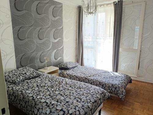 une chambre avec deux lits et un lustre dans l'établissement Stockholm, à Rennes