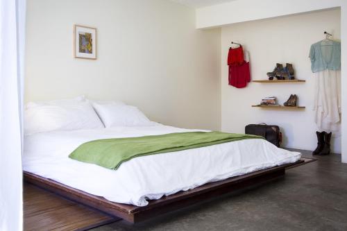 a bedroom with a bed with a green blanket on it at Hope Springs Resort in Desert Hot Springs