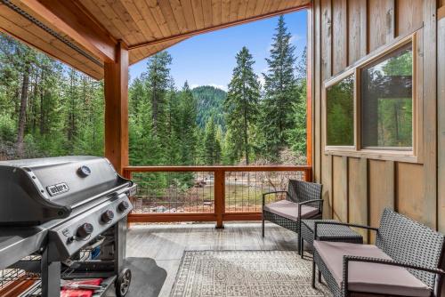 a screened in porch with a grill and a large window at Eagle Creek Hideaway in Leavenworth