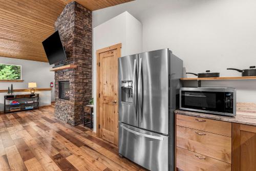 a kitchen with a stainless steel refrigerator and a fireplace at Eagle Creek Hideaway in Leavenworth