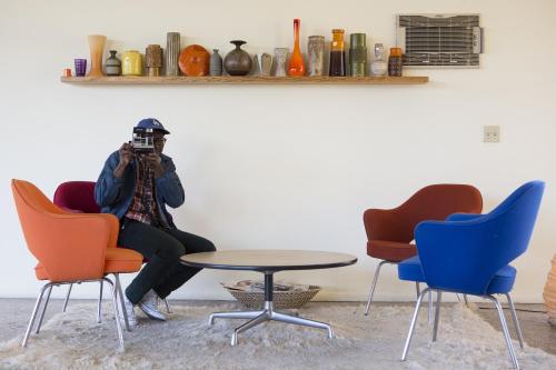 a person sitting in a chair taking a picture in a room at Hope Springs Resort in Desert Hot Springs