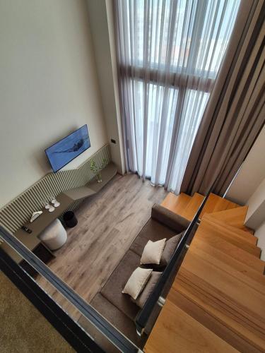 a living room with a bed and a large window at Meraviglia Boutique Hotel in Sarandë