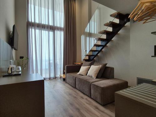a living room with a couch and a staircase at Meraviglia Boutique Hotel in Sarandë