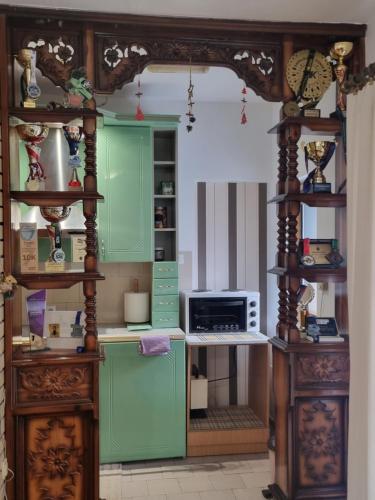 a kitchen with green cabinets and a microwave at Kraljevi Konaci Olja in Zlatibor