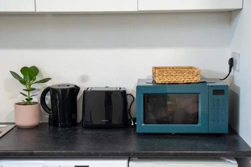 a microwave sitting on top of a kitchen counter at Lovely Studio Flat in Edgware HA8 in Edgware