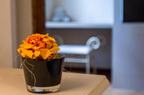 a vase with flowers in it sitting on a table at La Maison De Vì in Carpaneto Piacentino