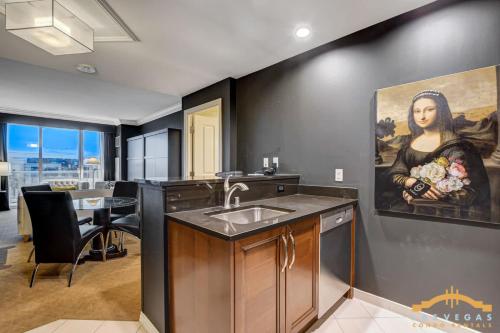 a kitchen with a sink and a painting of a woman at MGM Signature-04-602 1Br 2Ba Balcony Suite in Las Vegas