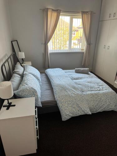 a bedroom with a bed and a window at Spacious 2 bedroom flat in Newcastle w Free parking in Kenton