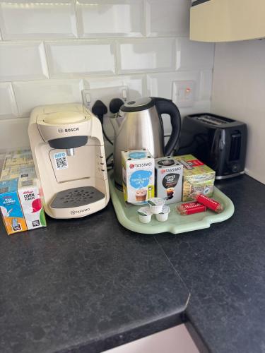 a kitchen counter with a coffee maker and a tea kettle at Spacious 2 bedroom flat in Newcastle w Free parking in Kenton
